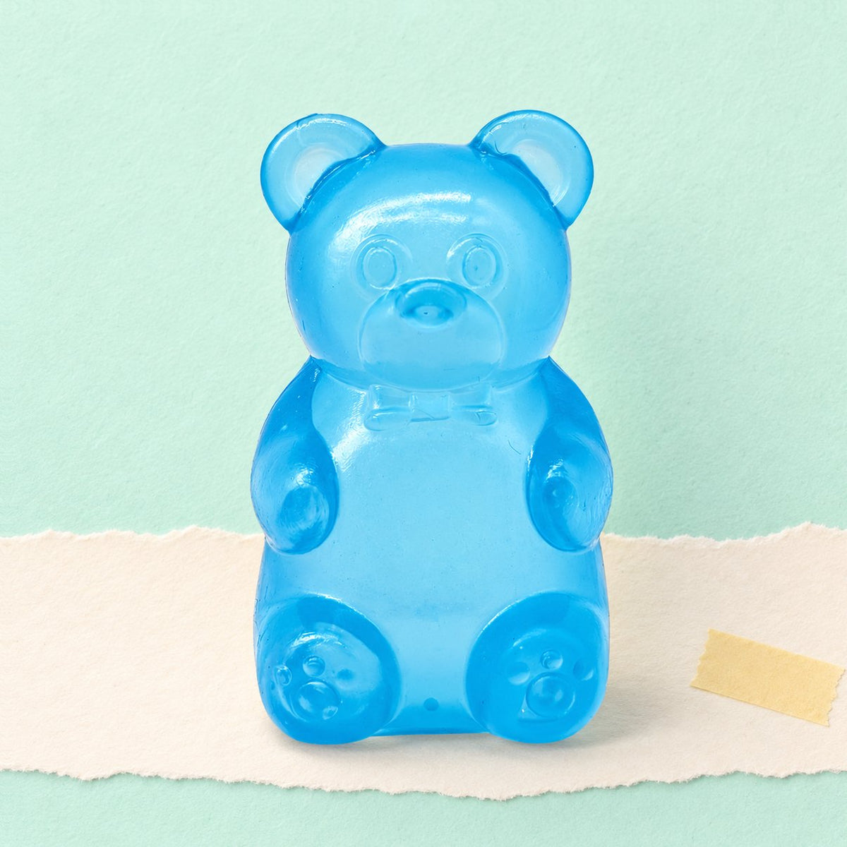 Blauwe gummibeer squishy op pastelkleurig papier