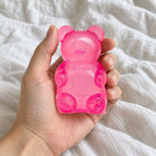 Gummy bear squishy (pink), held toward the camera, first-person view