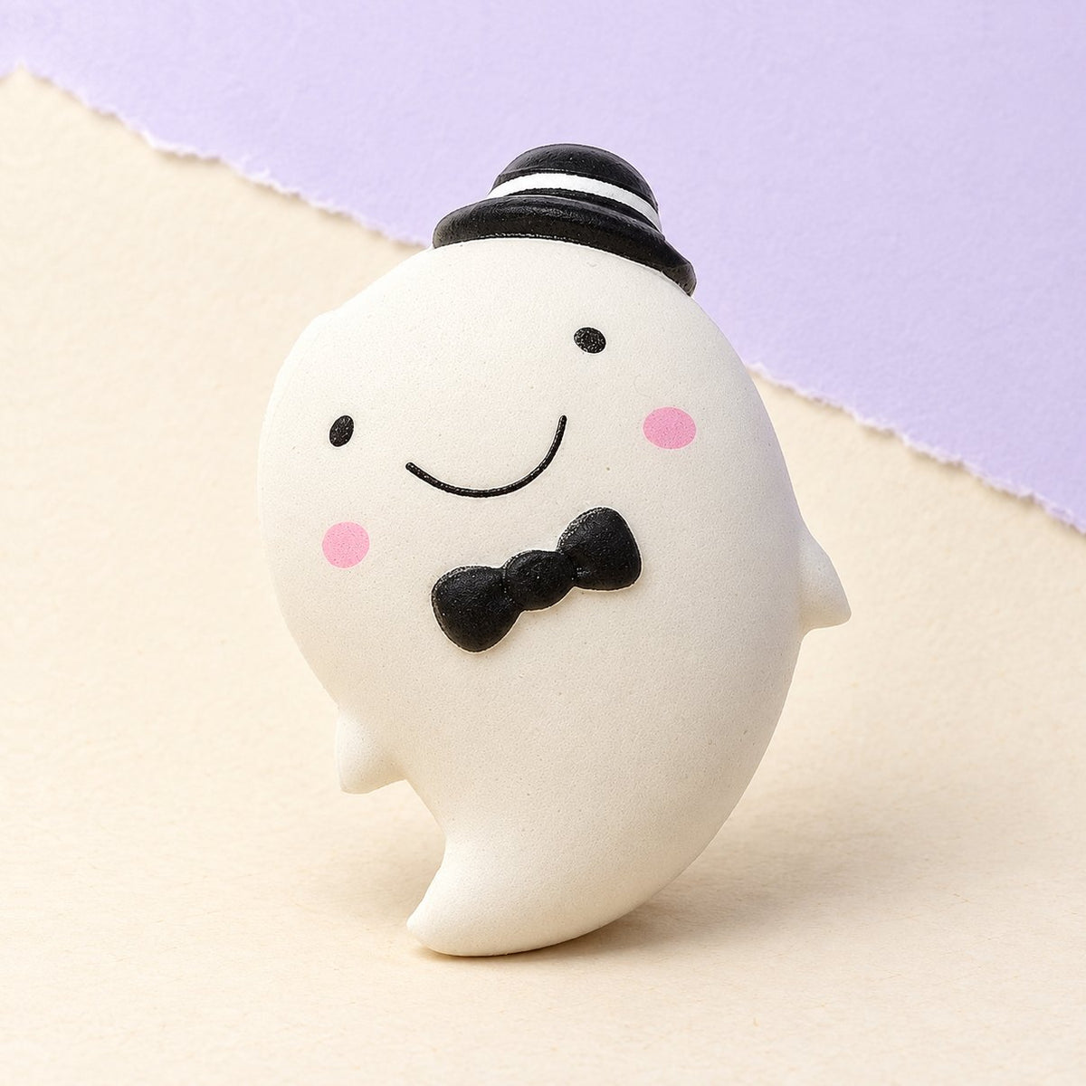Witte halloween squishy, een slow rising spookje van 14,5 cm, op pastelkleurig papier