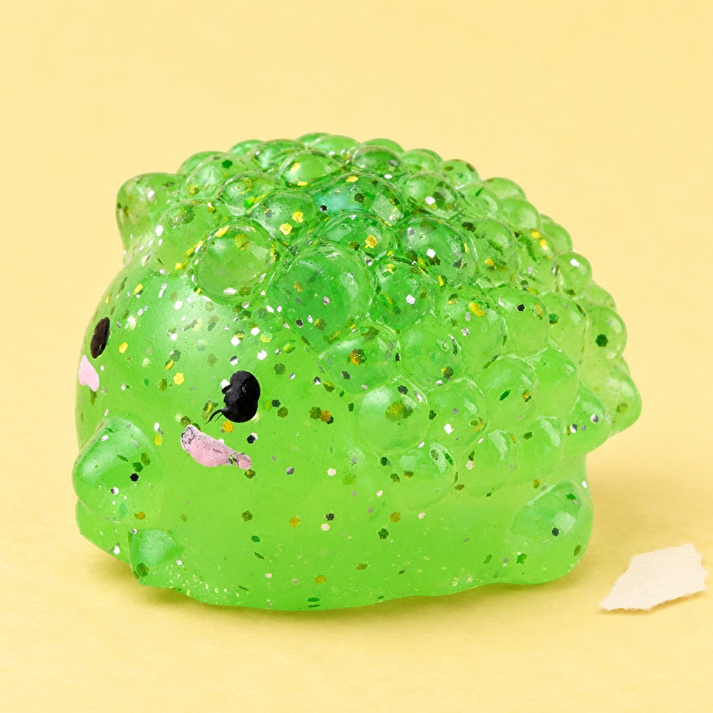 Hedgehog squishy mochi – Mochi Squishy Hedgehog with Glitter, product photo on pastel paper
