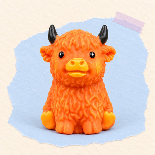 Squishy mucca highland crunchy morbido – Squishy mucca highland con ripieno che scricchiola (Arancio marrone), foto del prodotto su carta pastello