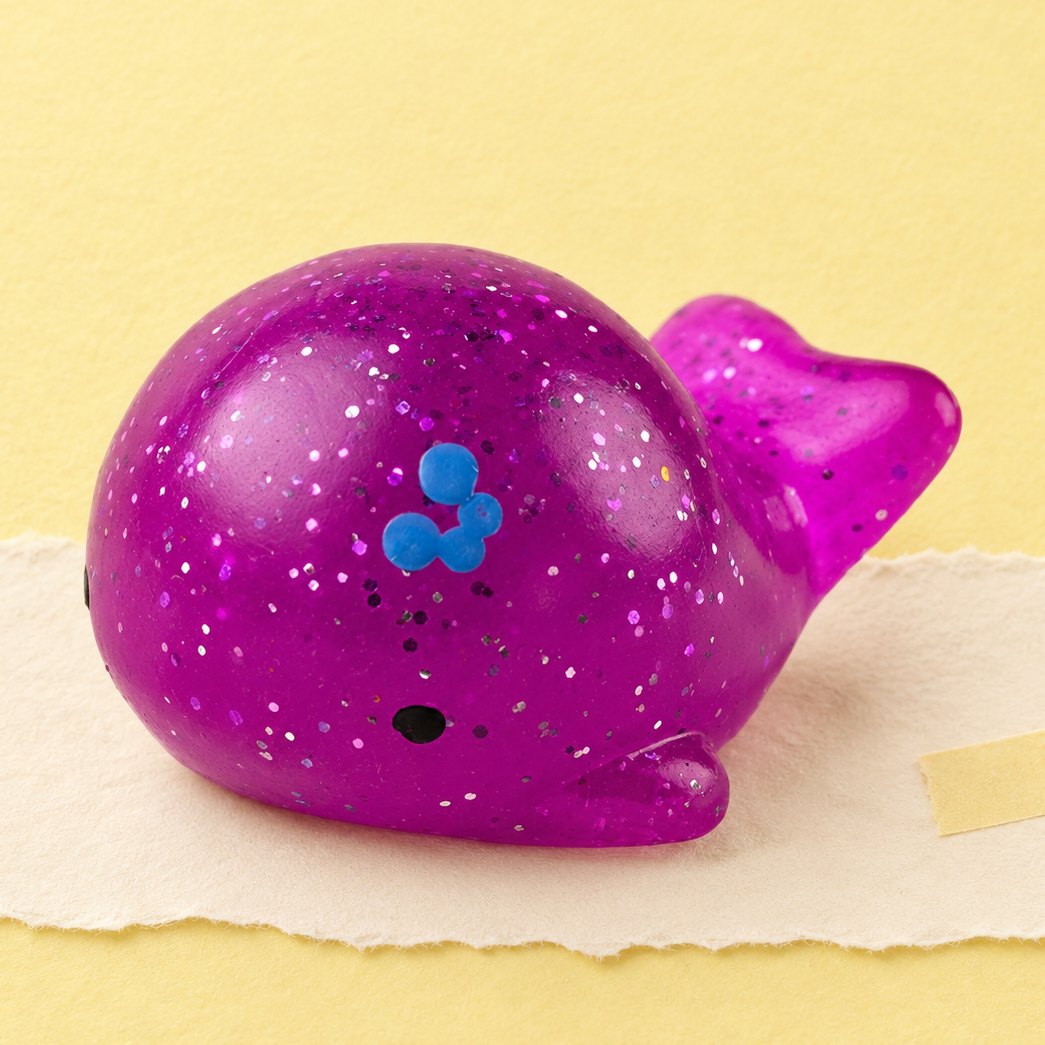 Hval-squishy med glimmer, produktfoto på pastelfarvet papir