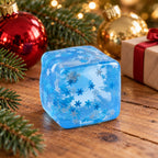 Ice Cube Squishy, 5 cm, Snowflake, Marble or Glitter, in a Christmas scene with fir branches and fairy lights
