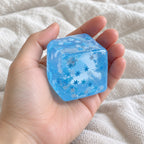 Ice cube squishy christmas (snowflake), held toward the camera, first-person view