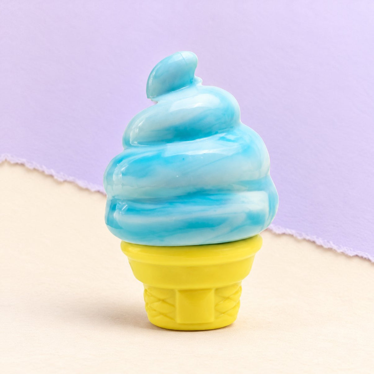 IJsje squishy in een hoorntje van rekbare siliconen, blauw, op pastelkleurig papier