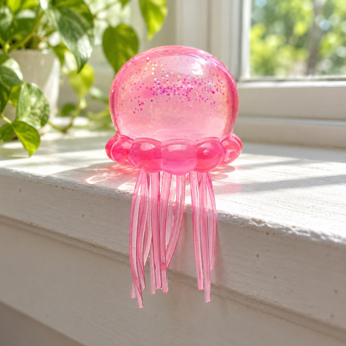 Jellyfish Squishy with Glitter, Soft TPR (pink), on a sunny windowsill