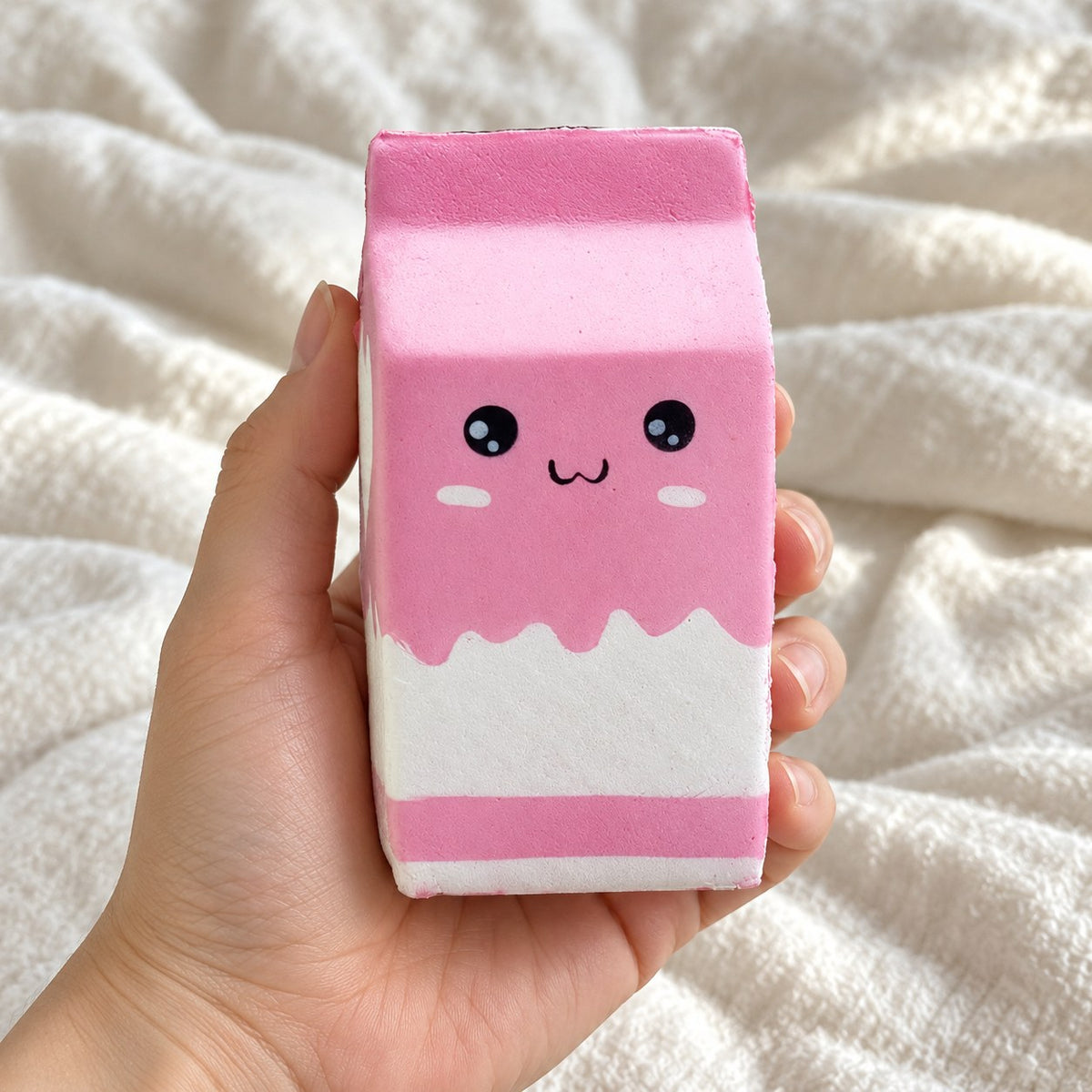 Milk carton squishy (pink), held toward the camera, first-person view