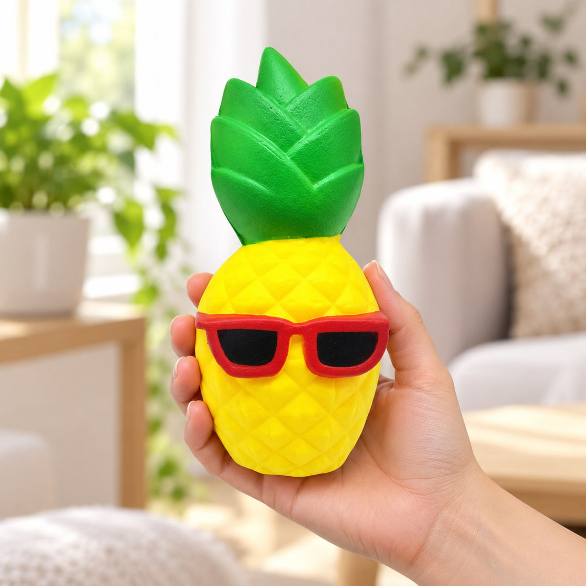 Jumbo Pineapple Squishy with Sunglasses, held in a hand to show the real size