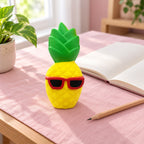 Jumbo Pineapple Squishy with Sunglasses, on a desk with a notebook and pencil