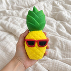 Jumbo Pineapple Squishy with Sunglasses, held toward the camera, first-person view