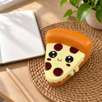 Pizza squishy, on a desk with a notebook and pencil