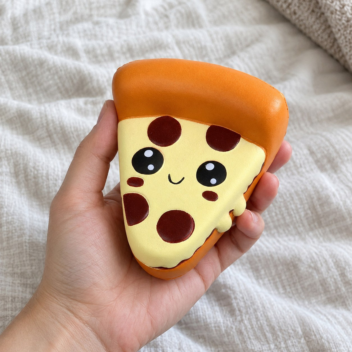 Pizza squishy jumbo, held toward the camera, first-person view