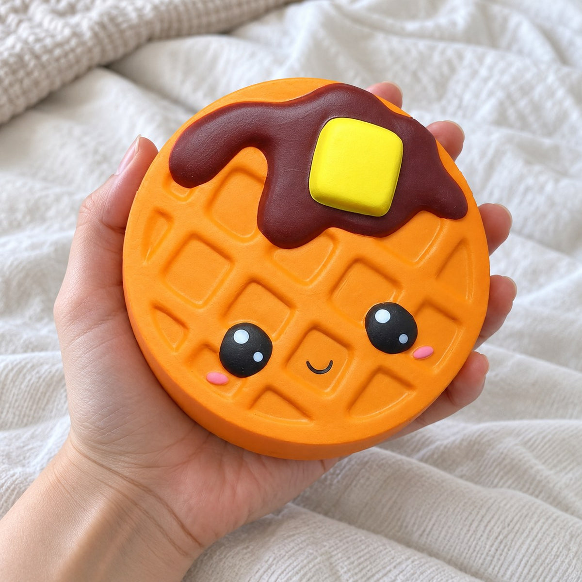 Waffle squishy jumbo, held toward the camera, first-person view