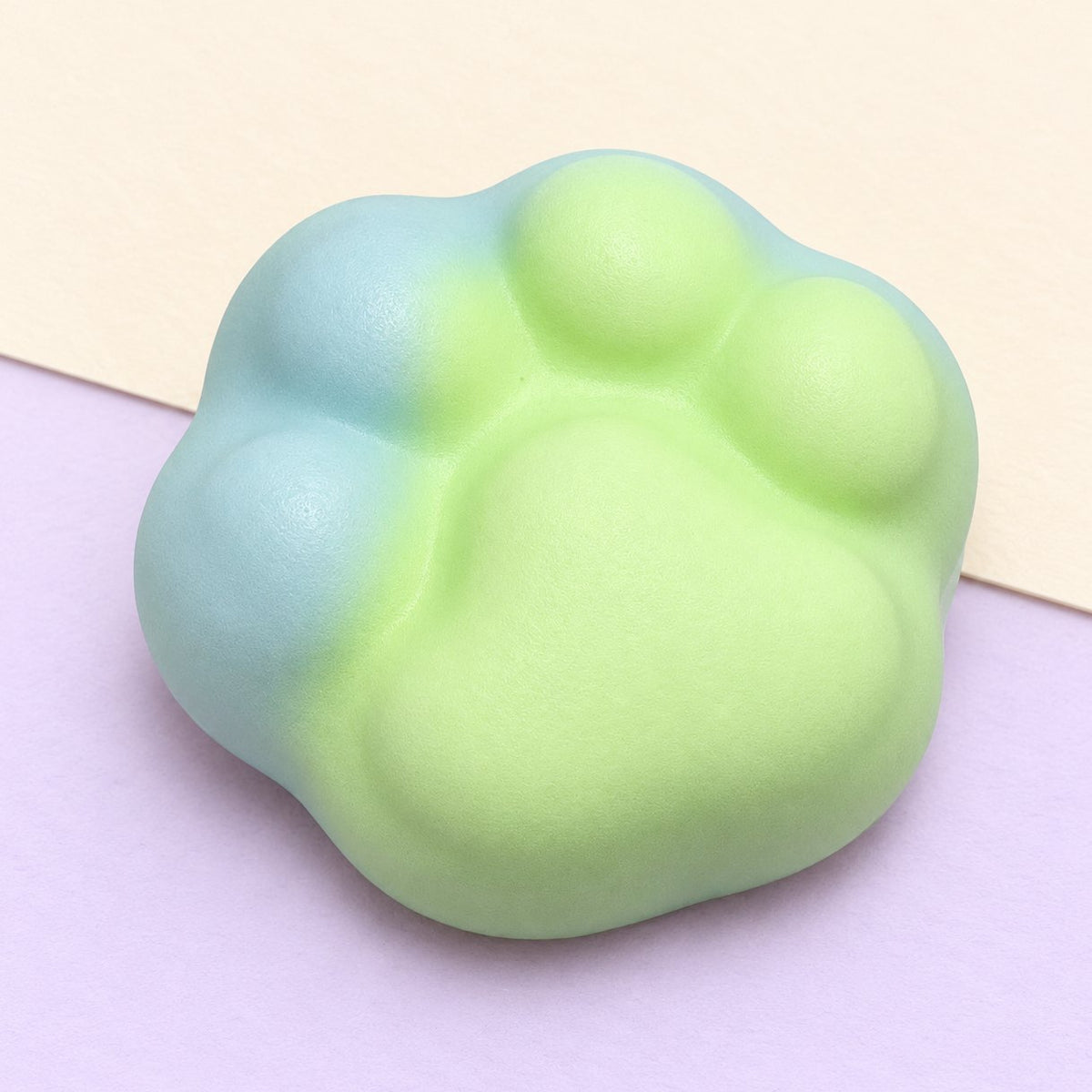 Katzenpfote Squishy crunchy in Grün, 6 cm, Produktfoto auf Pastellpapier