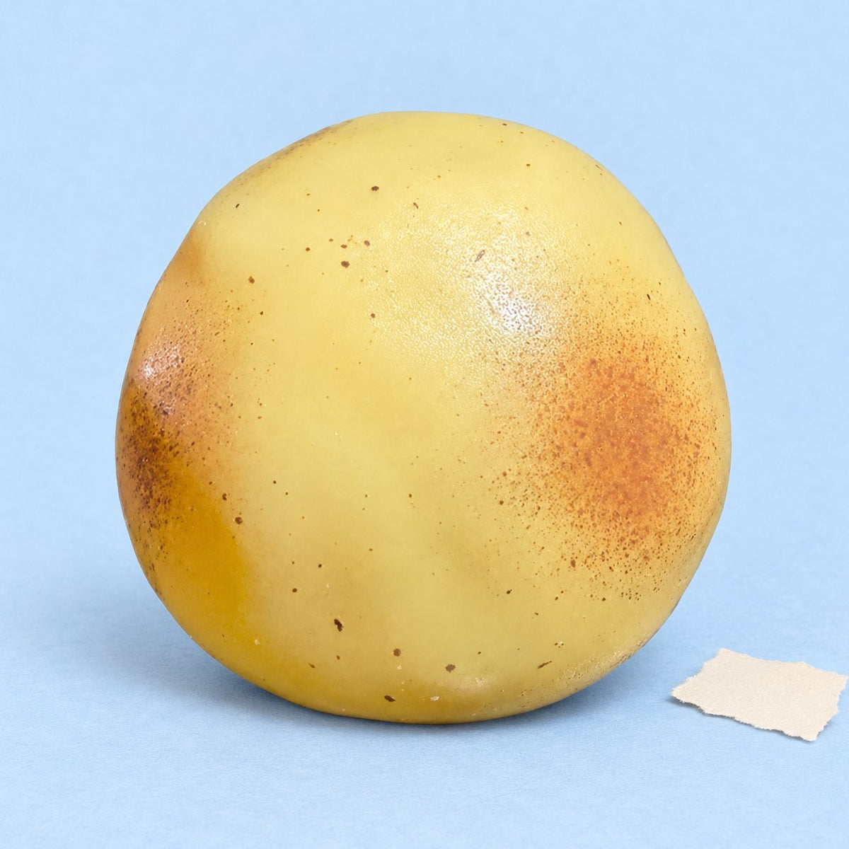 Kneedbare aardappel squishy die niet terugveert, op pastelkleurig papier