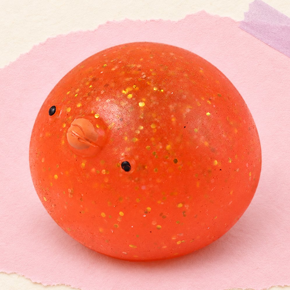 Kylling-squishy med glimmer, produktfoto på pastelfarvet papir