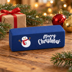 Merry Christmas Butter Squishy, 6 Colors, Slow Rising (Dark blue, snowman), in a Christmas scene with fir branches and fairy lights