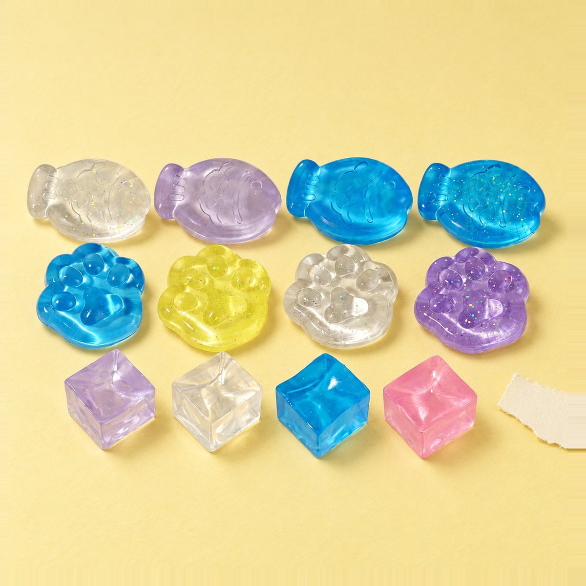 Mini mix squishy van gelei, 12 stuks als uitdeelcadeautjes op pastelkleurig papier
