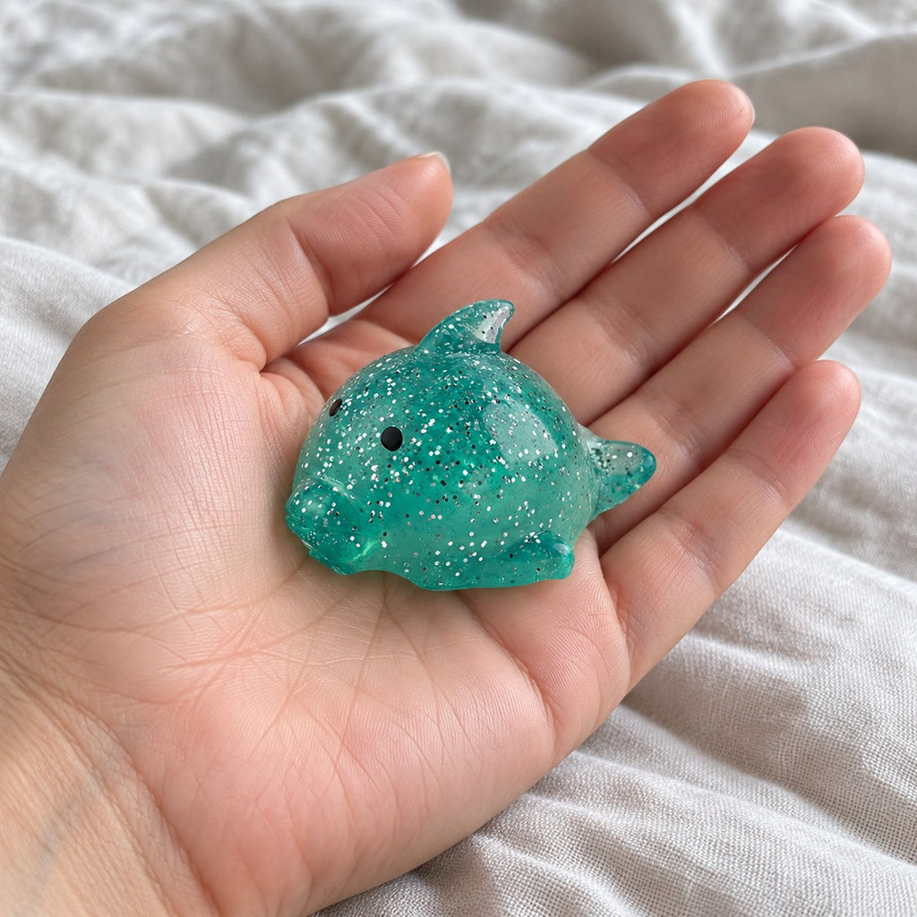 Big Mochi Squishy Dolphin with Glitter, held toward the camera, first-person view