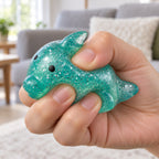 Big Mochi Squishy Dolphin with Glitter, being squeezed by hand, soft and squishy