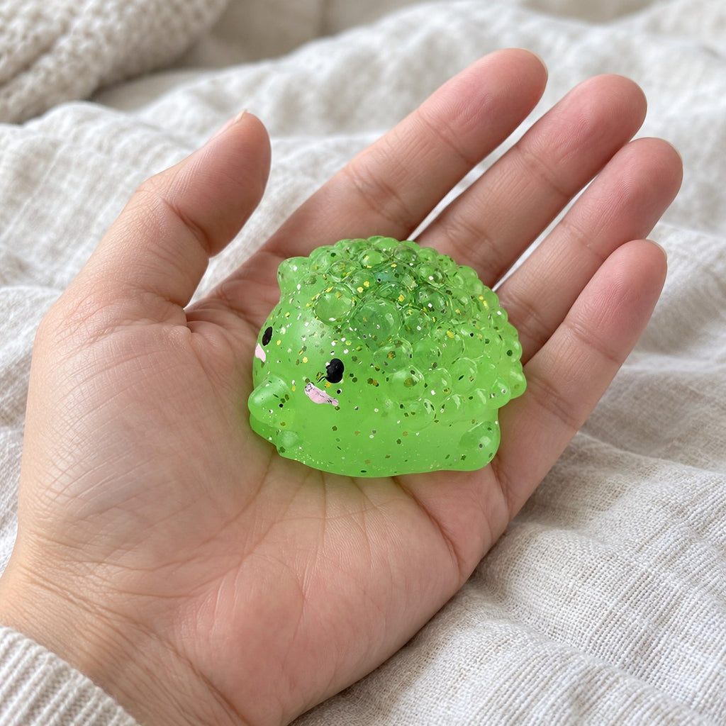 Hedgehog squishy mochi, held toward the camera, first-person view