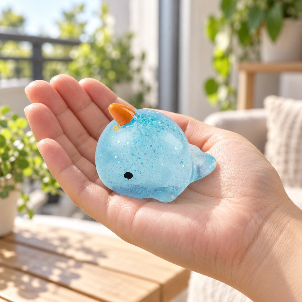 Mochi Squishy Narwhal with Glitter, held in a hand to show the real size