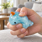 Mochi Squishy Narwhal with Glitter, being squeezed by hand, soft and squishy