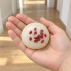 Red Bean Mochi Squishy, Handmade, held in a hand to show the real size