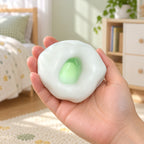 Mochi Squishy Rice Cake, Stretchy Ice Skin (green), held in a hand to show the real size