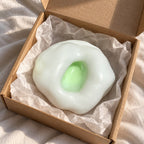 Rice cake squishy mochi (green), unboxed from a parcel with tissue paper