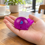 Mochi Squishy Whale with Glitter, held in a hand to show the real size
