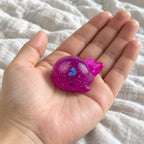 Mochi Squishy Whale with Glitter, held toward the camera, first-person view