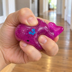 Mochi Squishy Whale with Glitter, being squeezed by hand, soft and squishy