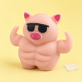 Pig squishy – Muscle Pig Squishy with Sunglasses, 12.5 cm, product photo on pastel paper