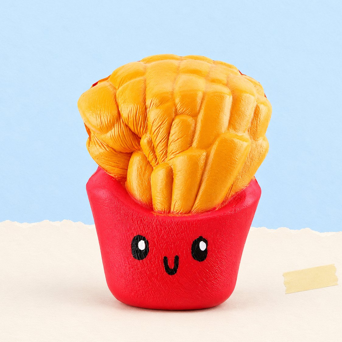 Patat squishy, kawaii en in jumbo-formaat, op pastelkleurig papier