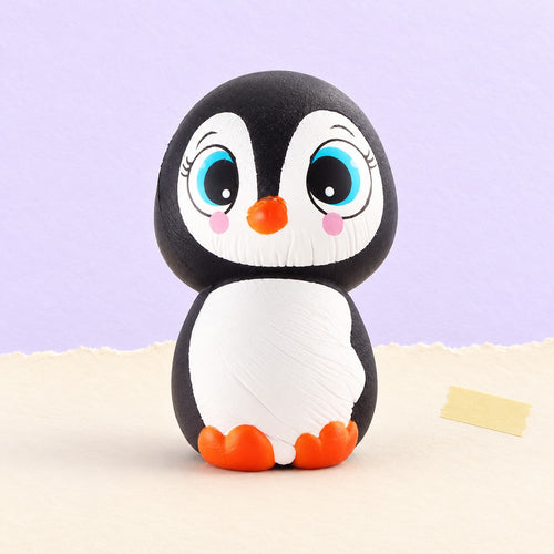 Squishy pingüino con ojos grandes slow rising – Squishy pingüino con ojos grandes, slow rising, 13,5 cm, foto del producto sobre papel pastel