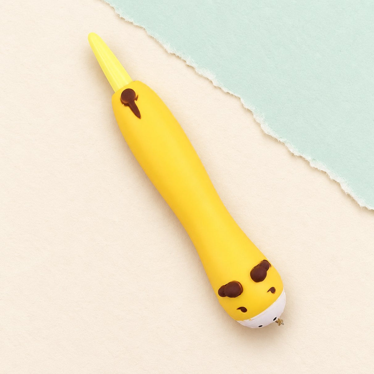 Penna squishy con animaletto vitellino in cima, su carta pastello