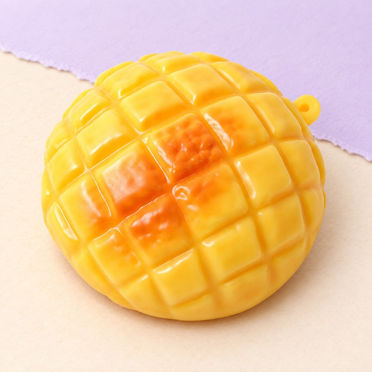 Pineapple bun squishy crunchy – Crunchy Pineapple Bun Squishy, 9 cm, product photo on pastel paper