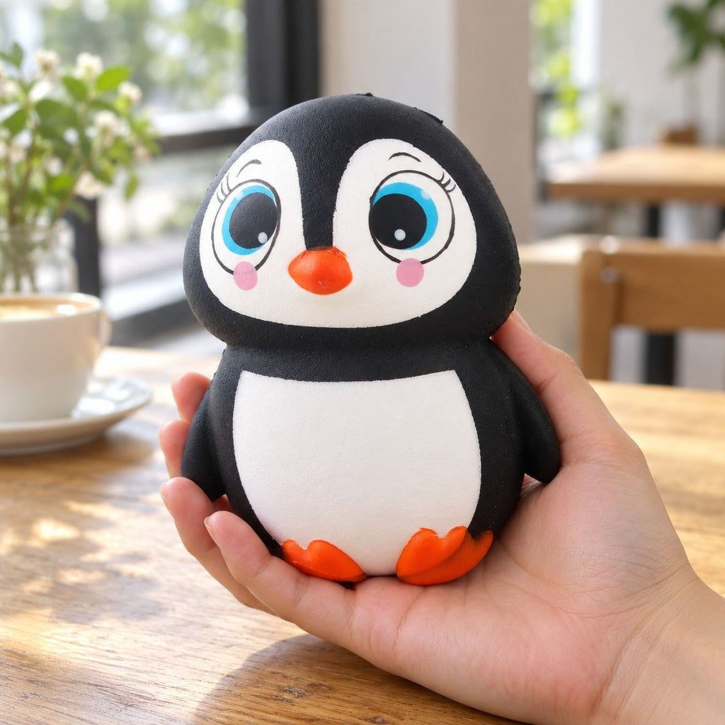 En hånd holder pingvin squishy, så størrelsen er tydelig