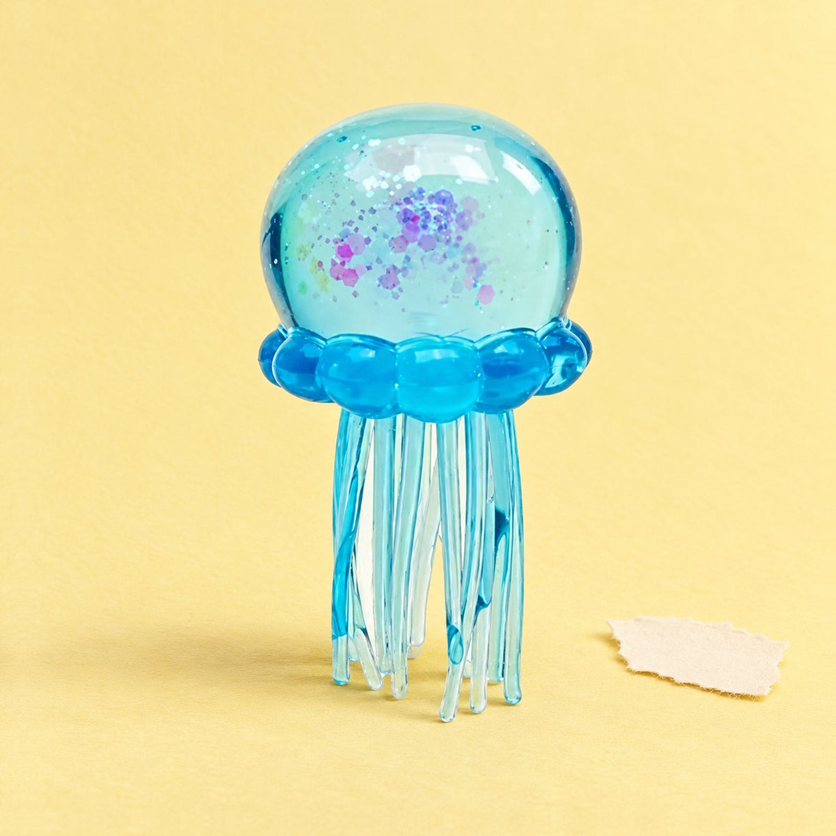 Qualle Squishy aus weichem TPR mit Glitzer, blau, auf Pastellpapier