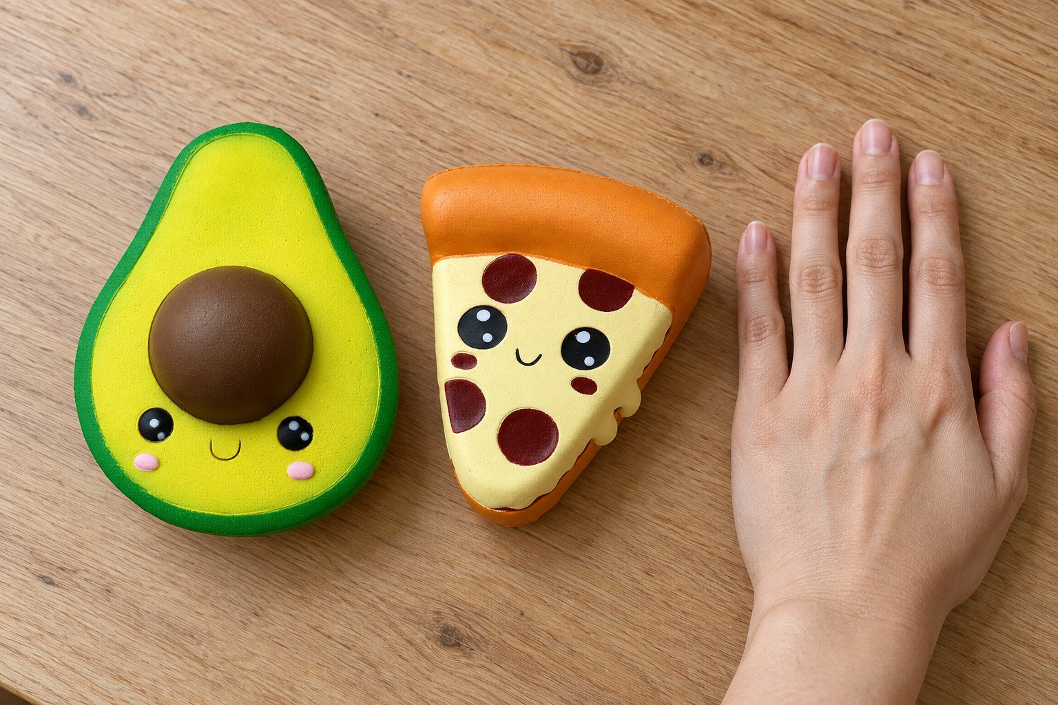 Riesiges Squishy neben einer offenen Hand: Jumbo-Avocado und Pizza, die Avocado ist fast so lang wie die Hand