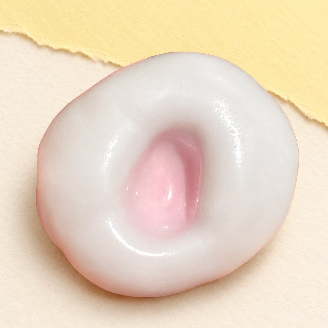 Aardbeiroze rijstcake squishy met rekbare ijshuid op pastelkleurig papier
