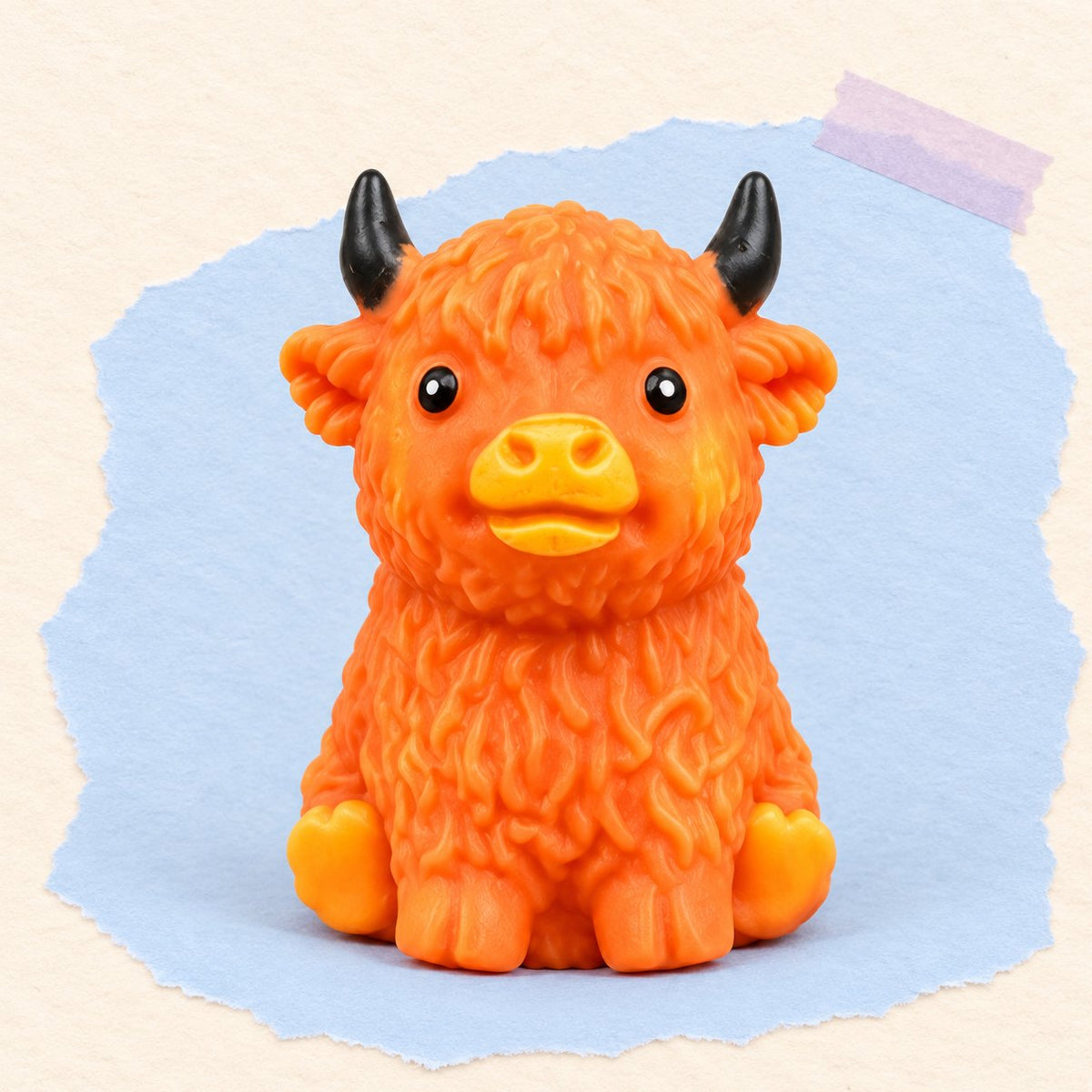 Oranjebruine schotse hooglander squishy crunchy met krakende vulling op pastelkleurig papier