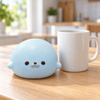Seal Dumpling Squishy, Slow Rising PU (blue), next to a coffee mug for size comparison