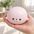 Seal Dumpling Squishy, Slow Rising PU (pink), held in a hand to show the real size