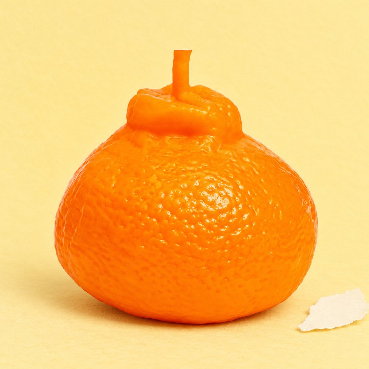 Levensechte sinaasappel squishy op pastelkleurig papier