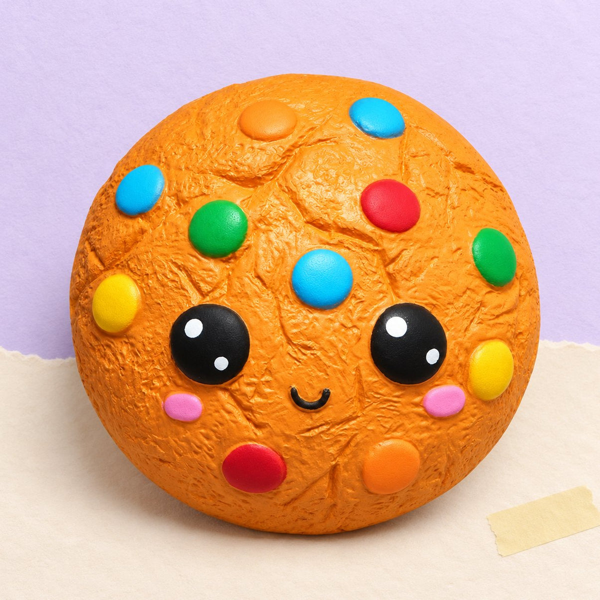 Snoepkoekje squishy, een kawaii koekje met snoepjes, op pastelkleurig papier