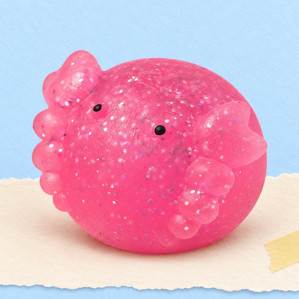 Squishy axolotl mochi con glitter fotografato su carta color pastello