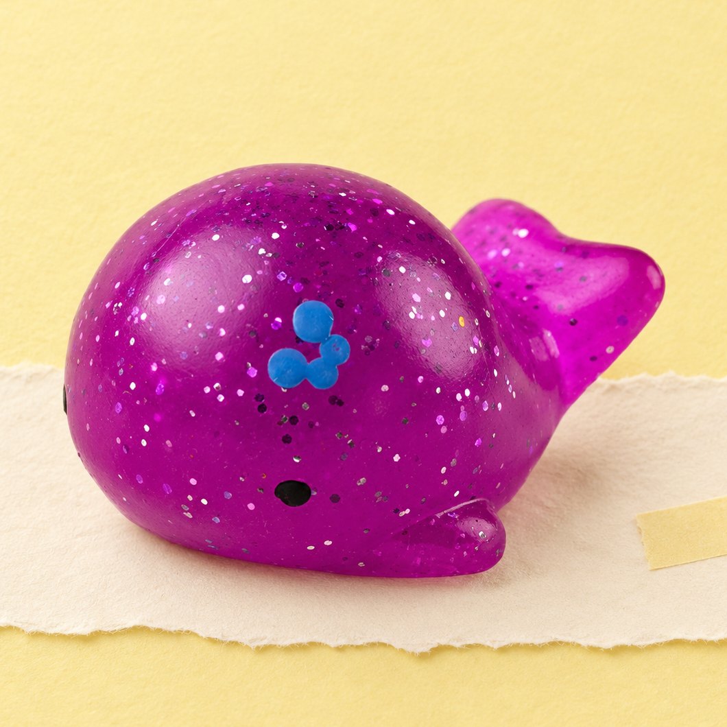 Squishy balena con glitter fotografato su carta color pastello