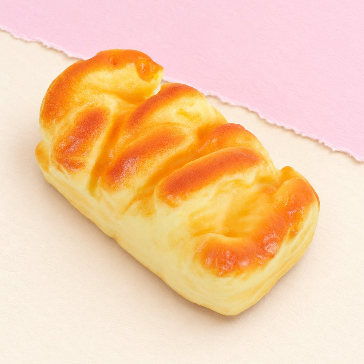 Squishy brioche con forma de molde, 11 cm, sobre papel pastel